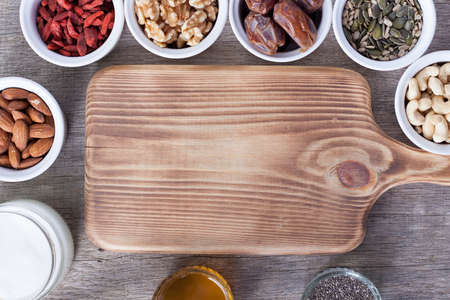 Grain free oat free paleo granola ingredients: mixed nuts, seeds, goji berries, chia, honey and coconut oil, selective focusの写真素材