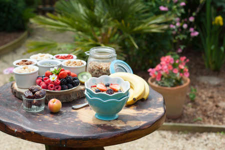 Paleo style breakfast served in the garden: gluten free grain free oat free granola with mixed nuts, and fresh berries and fruits, selective focusの写真素材