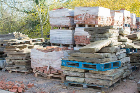 Reclamation yard background: stacks of paving slabs and reclaimed bricks on the pallets, selecive focusの写真素材