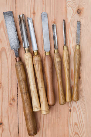 Old used wood lathe chisels selection on the wooden table, selective focus