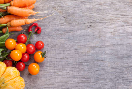Autumn vegetables background: tomatoes, carrots, pumpkin, runner beans, chiliesの写真素材