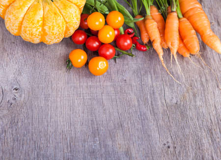 Autumn vegetables background: tomatoes, carrots, pumpkin, runner beans, chiliesの写真素材