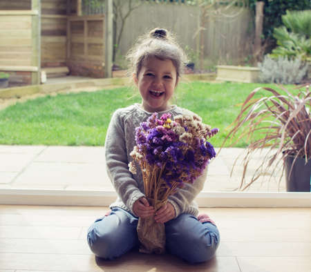 Little toddler girl sitting on the floor holding staticesの写真素材