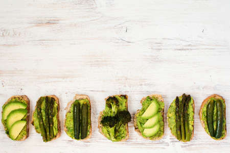 Green vegetarian sandwiches selection made with avocado, courgette, asparagus, broccoli, top view, copy spaceの写真素材