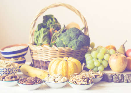 Variety of fruits and vegetables, nuts, cereals, ham, cheese on the white wooden table, selecitve focusの写真素材