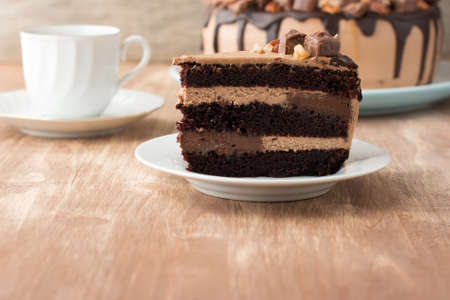 Cut piece of chocolate and pecan cake with cream cheese frosting and chocolate custard mousse, with...