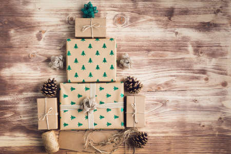 Christmas concept, Christmas tree made of brown present boxes, pine cones, jute twine, top view,...
