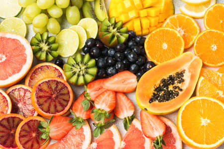 Healthy colourful fruits pattern background, strawberries, mango, grapes, bananas, grapefruit on the off white table, top view, selective focusの写真素材