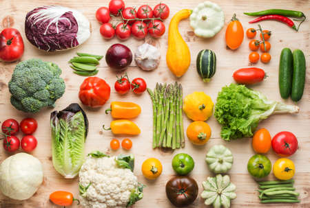 Assortment of fresh colorful organic vegetables on wooden pine table, creative food background,...