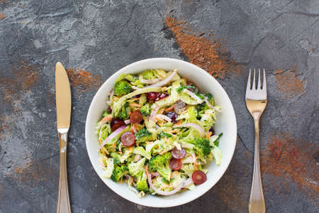 Broccoli slaw salad made with grapes, cabbage, red onion, carrots, top view, copy space for text, selective focusの写真素材