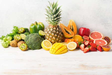 Vitamin C fruits and vegetables in rainbow colors, oranges mango grapefruit kiwi kale pepper...