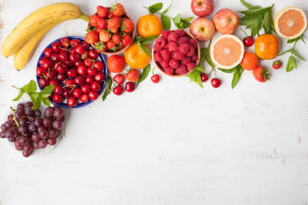 Summer fruits and berries, strawberries, cherries, raspberries, oranges, grapes, persimmon on a...