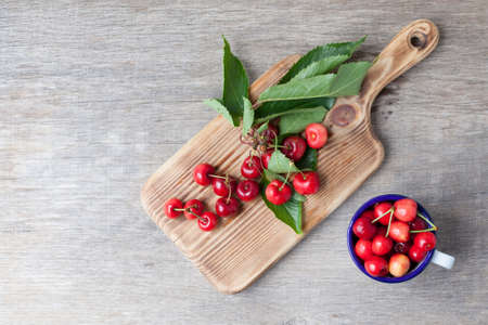 Cherries in enamel mug on the table close up, top view, selective focusの写真素材