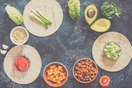Ingredients for vegan tortillas: chickpeas, butternut squash, spring onion, cucumber, avocado on the...