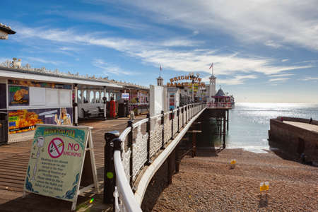 Brighton, England, October 07, 2018. VIew of the Brighton pier with blue sea and shingle beach, selective focusのeditorial素材