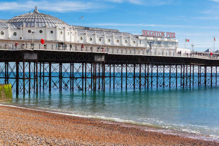 Brighton, England, October 07, 2018. VIew of the Brighton pier with blue sea and shingle beach, selective focusのeditorial素材