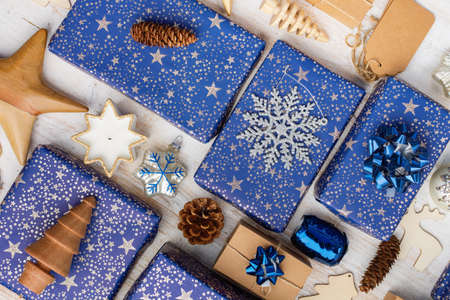 Creative christmas composition. Presents in blue wrapping paper with silver sparkles, wooden...