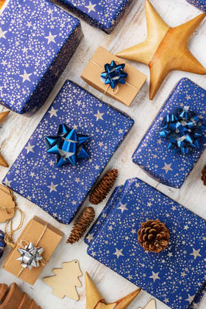 Creative christmas composition. Presents in blue wrapping paper with silver sparkles, wooden...