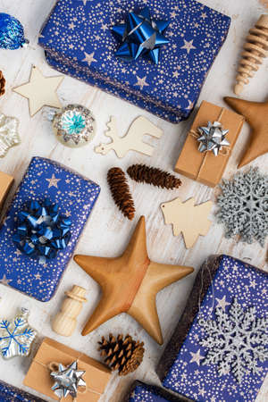 Creative christmas composition. Presents in blue wrapping paper with silver sparkles, wooden...