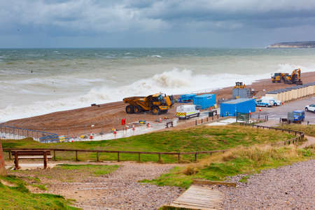 SEAFORD, ENGLAND - 7 November, 2018. View of sea from Seaford beach, rough sea, diggers on the coast, beach repairs, East Sussex, Englandのeditorial素材