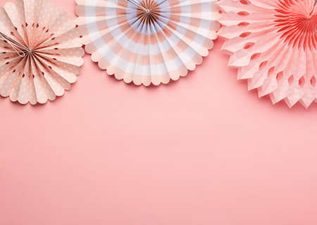 Chinese paper fans in pastel colors on pink table, top view, copy space for text, selective focusの写真素材