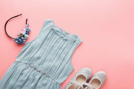 Girls fashion background blue tulle dress, sparkly shoes, flower headband on pink, flat lay, top view, toned photo, copy space for text, selective focusの写真素材