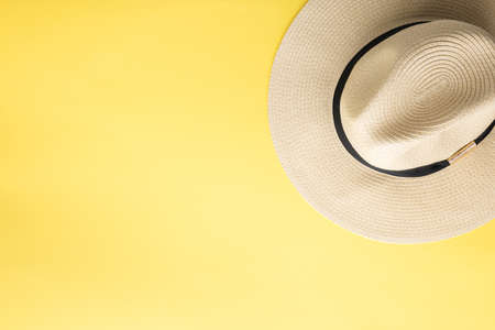 Straw hat on yellow background, beach holiday concept. Top view, selective focusの写真素材