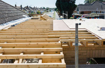 Renovation projects. Building of extension of the existing house, unfinished wooden roof structure,...