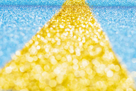 Abstract photo of the golden road made of gliter on sparkly blue card background, selective focus,...