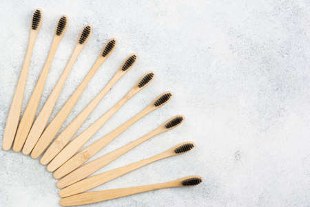 Zero waste eco friendly bamboo toothbrushes on white table, top view, selective focus