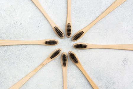 Zero waste eco friendly bamboo toothbrushes on white table, top view, selective focus
