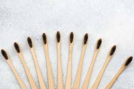 Zero waste eco friendly bamboo toothbrushes on white table, top view, selective focus