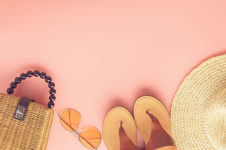 Summer fashion background on pink, trendy straw bag, fedora hat, leather sandals and yellow sunglasses, flat lay, top view, selective focusの写真素材