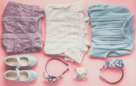 Toned photo of girls fashion background in pastel colors, lace and tulle dresses, flower headbands, flat lay, top view, selective focusの写真素材
