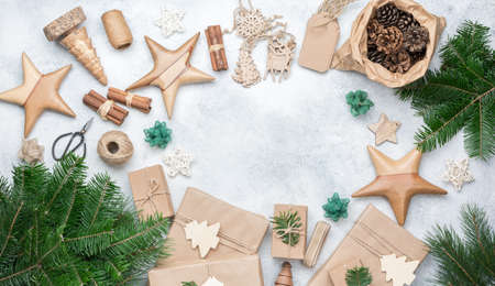 Christmas frame background. Top view of fir tree branhes, brown gift boxes, various accessories for...