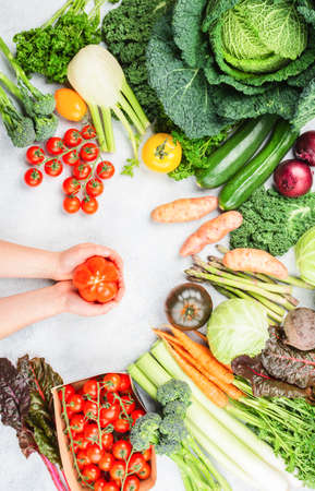 Healthy eating concept, Hands holding tomato. Organic vegetables broccoli cauliflower carrots kale...