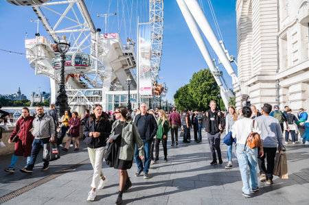 People walking towards London Eye ferris wheel