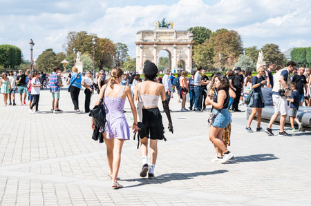 Paris, France - August 26 2022: People walking near Arc de Triomphe du Carrousel, meaning triumphal arch in Paris, located in the Place du Carrousel, Franceのeditorial素材