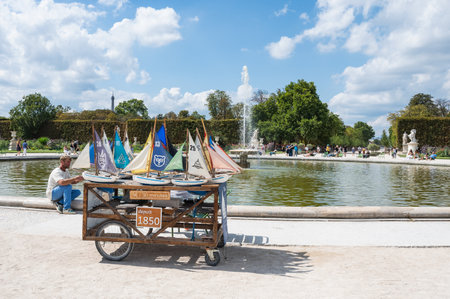 Paris, France - August 26 2022: Fouintains in Tuileries gardens near Arc de Triomphe du Carrousel, meaning triumphal arch located in Place Carrousel. Kids model boats to rentのeditorial素材