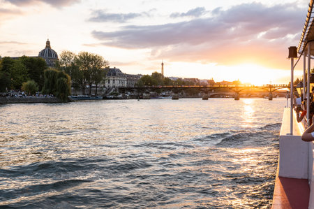 Paris, France - August 26 2022: People on boat taking photos of sunset at Bridge Pont des Arts, Paris, France, pedestrian bridge that has an international reputation as the bridge of romance.のeditorial素材
