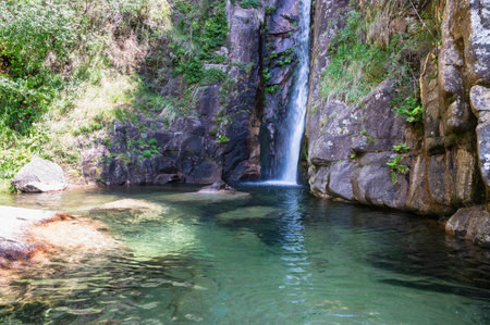 Picturesque Pincaes waterfall with a natural emerald pool located in a peaceful forest area, Peneda Geres National park, North Portugalの写真素材