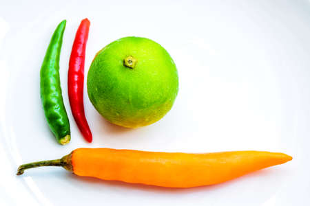 Chilli and lemon on a wood dishの写真素材