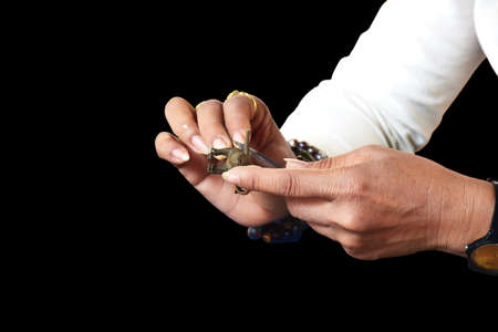 Close-up of hands woman creating clay buffalo isolated on black background