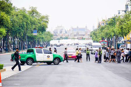 Bangkok, Thailand, November 5, 2017. Policeman stop the cars for people crossing the road go to...