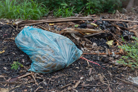 The blue garbage bags made from plastic materials are disposed of and prepared to be burned on an...