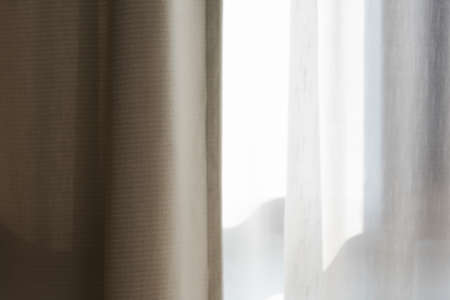 Curtain in the room, which is exposed to the sun, shining light.の写真素材