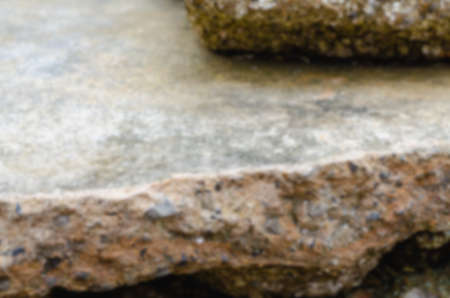 A blurred picture of a rocky reef along the beach that has many shellfish remains.の写真素材
