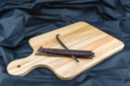 The blurred of the vanilla bean was placed on a wooden tray with a black cloth underneath.の写真素材