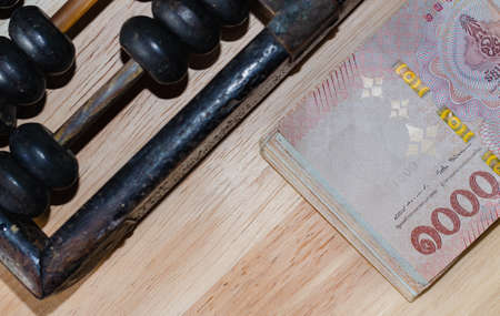 A picture of a banknote in Thai currency, which is a bunch of one thousand baht notes with black...