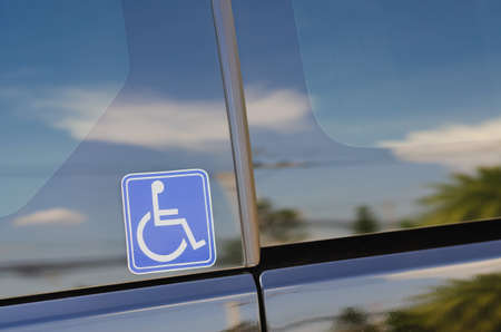 The sticker showing the disabled person symbol is affixed to the glass on the side of the vehicle.の写真素材